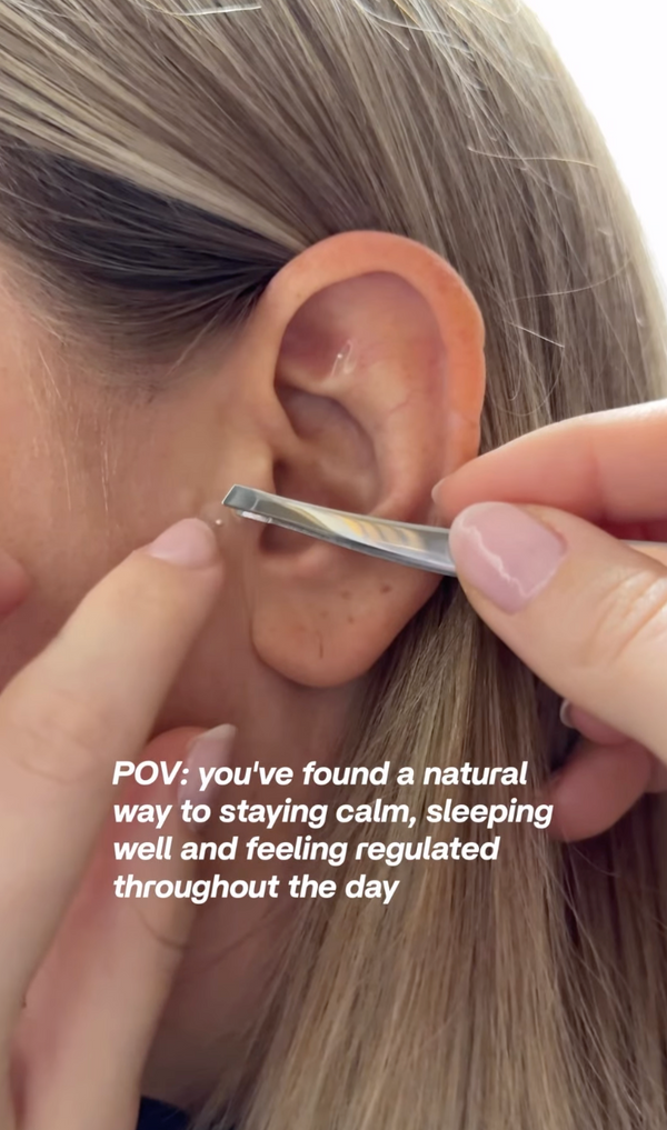 Person applying ear seeds on their ear with a text overlay about natural ways to stay calm.
