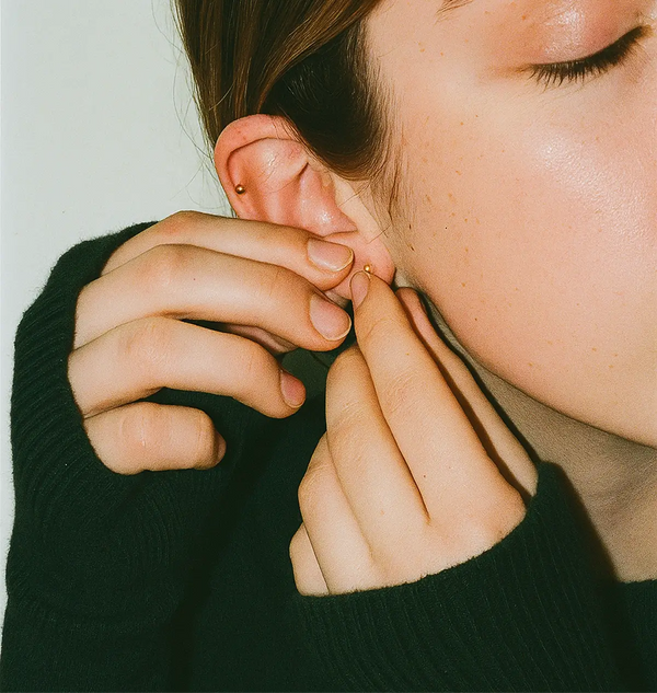Close-up of a person pressing in ear seeds.
